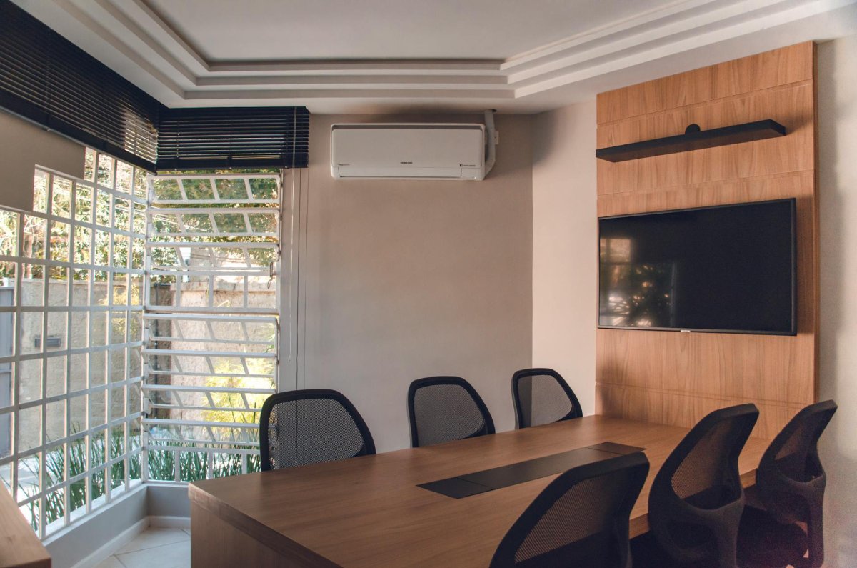 Sala de reunião moderna com mesa de madeira e cadeiras executivas