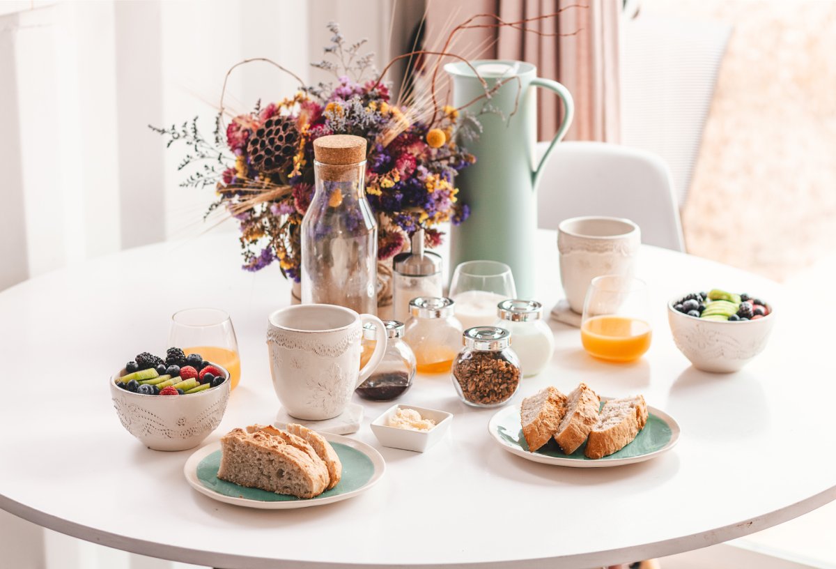 Café da manhã com pães, café e suco em uma bandeja