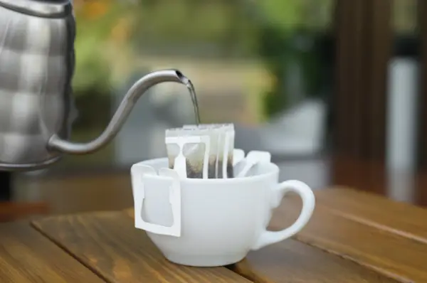 Água quente sendo despejada lentamente sobre café filtrado