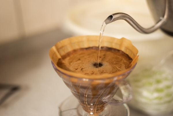 Café moído sendo preparado em coador sobre uma xícara