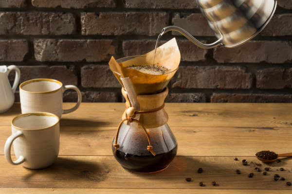Água quente sendo despejada lentamente sobre filtro individual de café