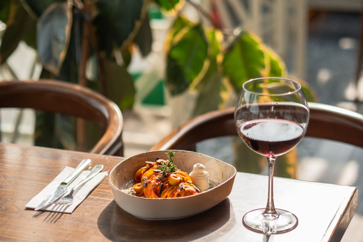 Massa acompanhada por taça de vinho tinto