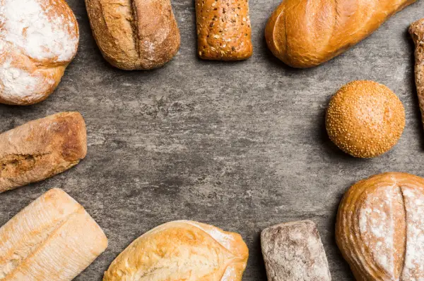 Pães de diferentes formatos sobre uma mesa de café da manhã