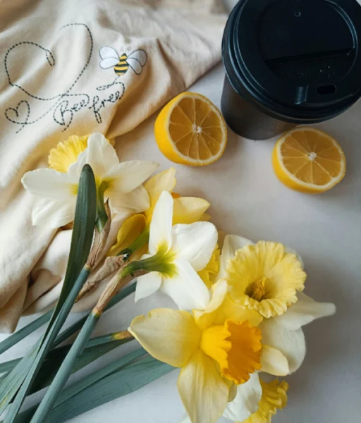 Café preto acompanhado por referências florais de jasmim e limão