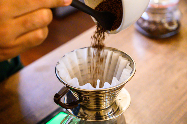 Café moído e coador usados no preparo de duas xícaras