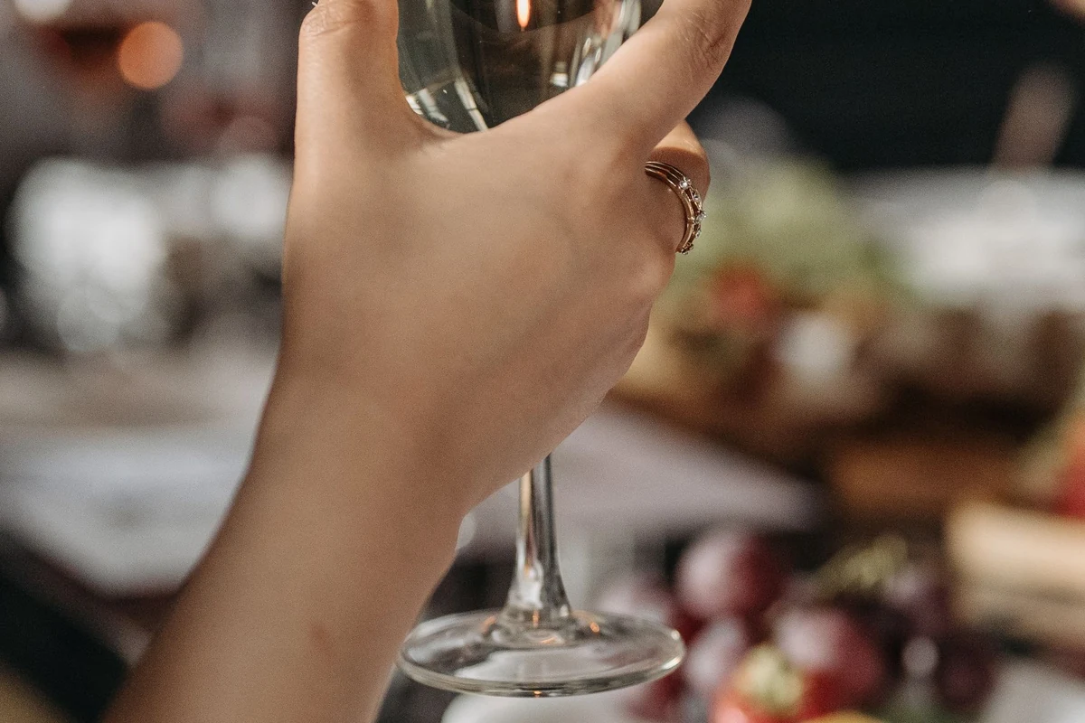 Pessoa degustando Saint Felicien Sauvignon Blanc 2022 em taça de vinho branco, na tonalidade indicada pela ficha