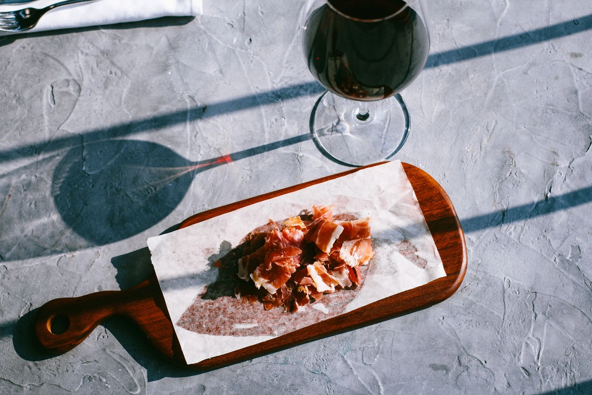 Charcutaria ao lado de uma taça de vinho tinto
