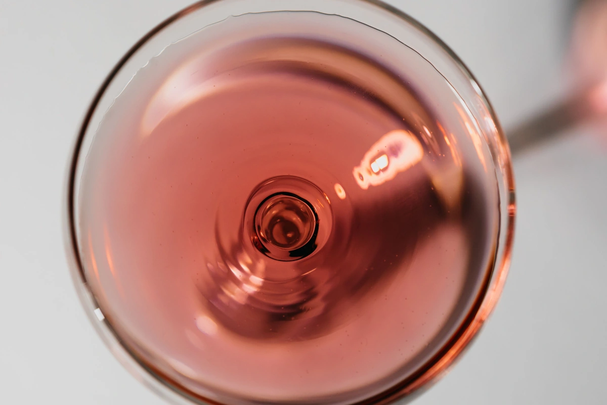 Taça de vinho rosé vista de cima sobre fundo claro
