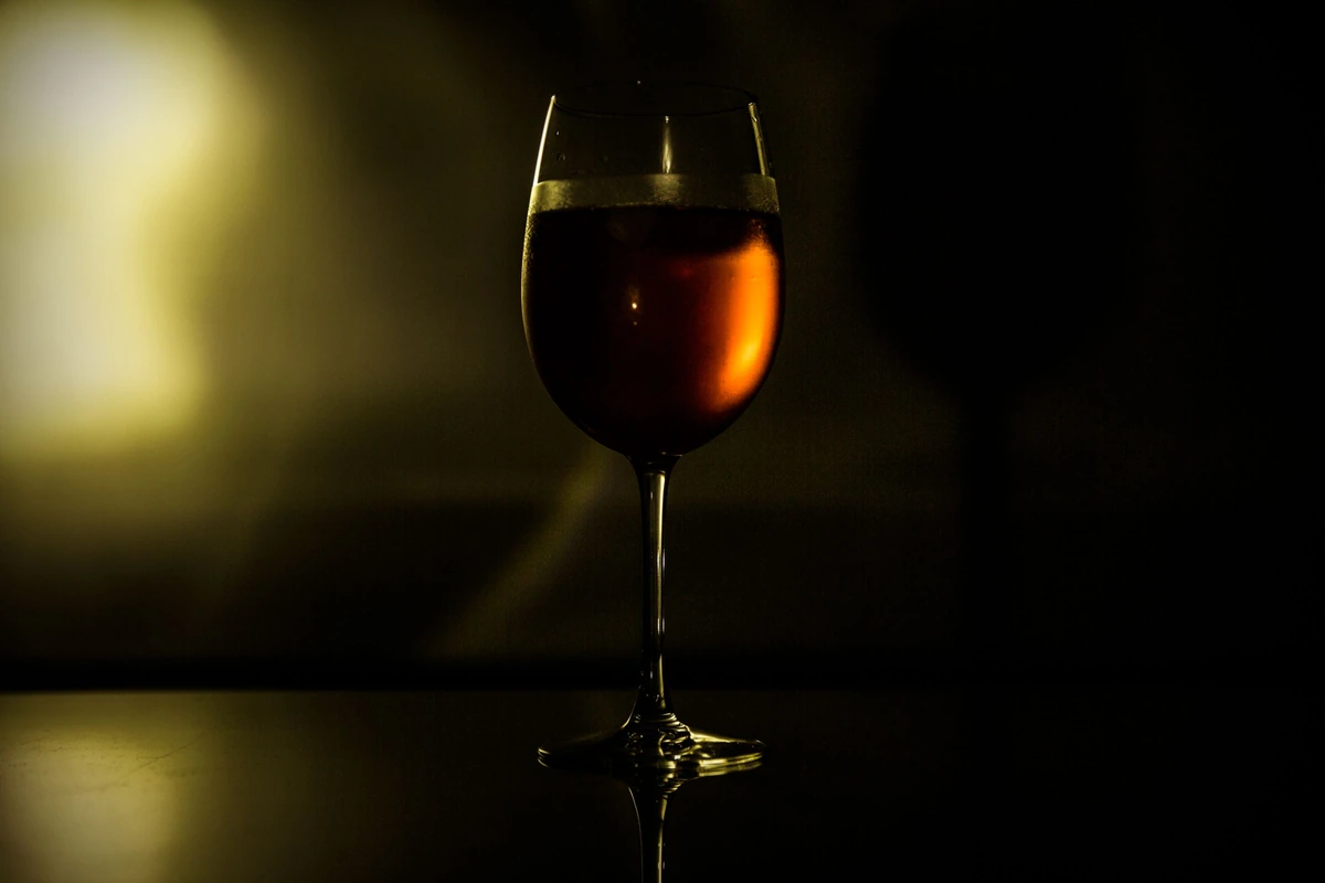Taça com vinho tinto em iluminação ambiente