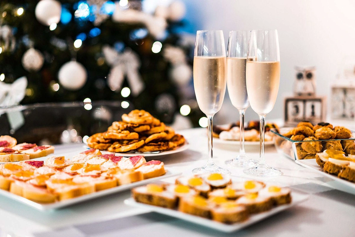 Taças preenchidas com espumante palha ao lado de canapés salgados de pão, alguns cobertos com fatias de ovo.