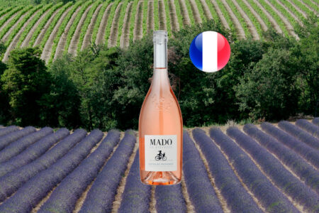 Mado en Provence Rosé ao centro de uma paisagem horizontal com lavanda em primeiro plano e vinhedos ao fundo.