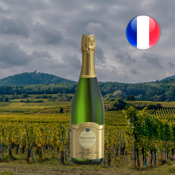 Garrafa de Ruhlmann Jean-Charles Brut Crémant d'Alsace diante de vinhedos sob céu nublado, com bandeira francesa.