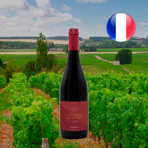 Garrafa de Chevalier des Arenes com cápsula vermelha e rótulo bordô, diante de vinhedos verdes e bandeira da França.