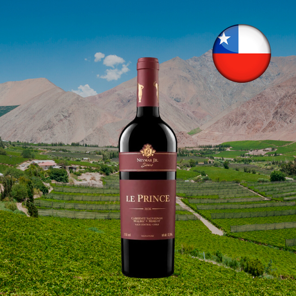 Garrafa do vinho tinto Le Prince Neymar Jr Signature Red Blend, com cápsula e rótulos bordô, diante de vinhedos verdes e montanhas áridas, com bandeira do Chile.